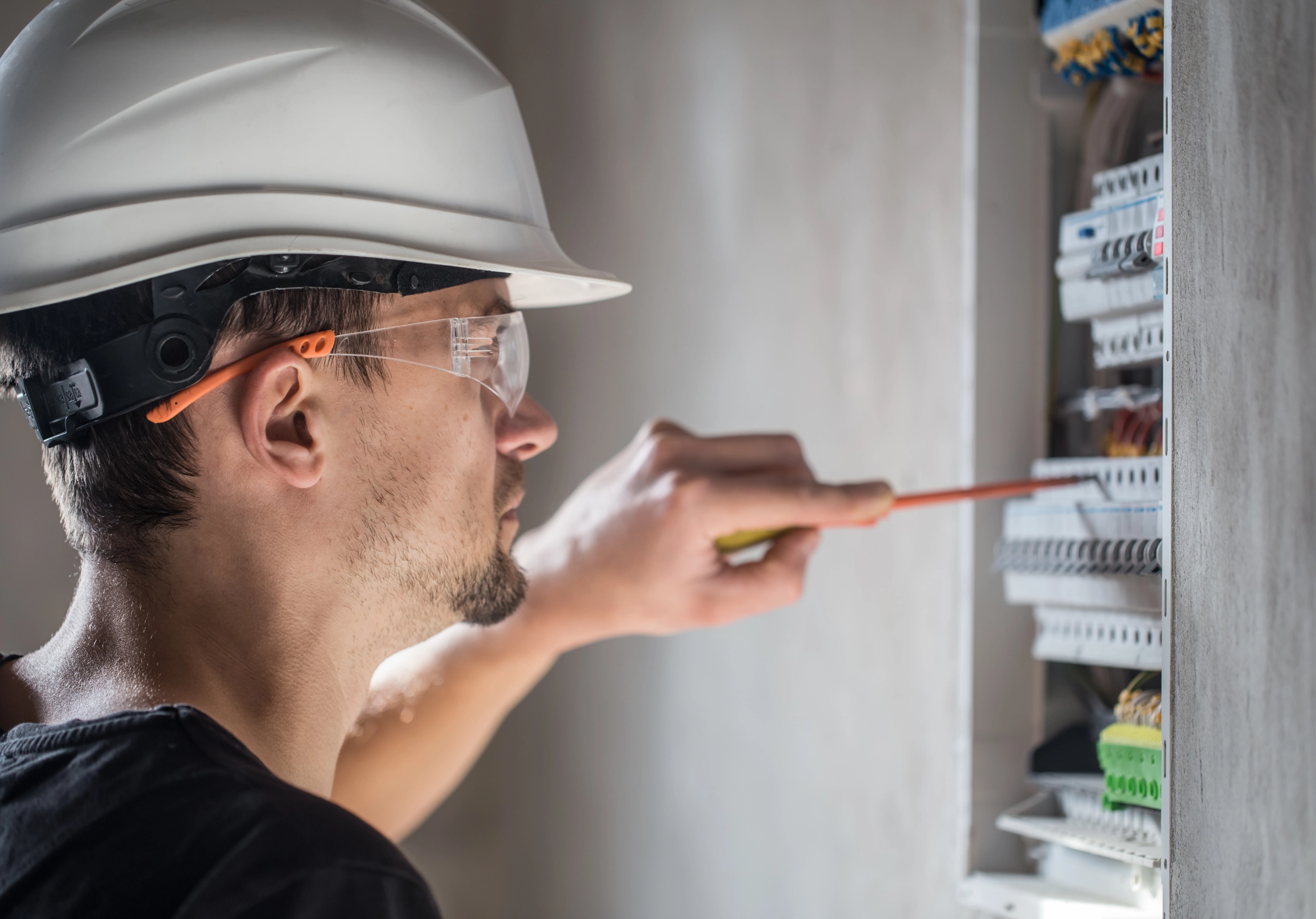 man, an electrical technician working in a switchboard with fuses. Installation and connection of electrical equipment. Close up.
